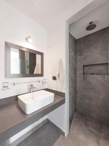a white bathroom with a sink and a shower at Escape to Tulum, Luxury Apt, Pool & pet friendly in Tulum