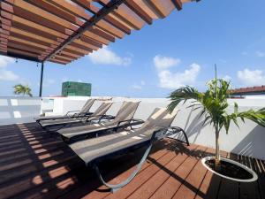 a group of lounge chairs sitting on a deck at Escape to Tulum, Luxury Apt, Pool & pet friendly in Tulum