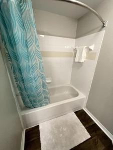 W łazience znajduje się wanna z zasłoną prysznicową. w obiekcie Newly Renovated! Spacious & Large Windows, Near UF w mieście Gainesville