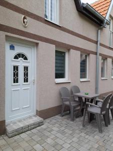 un patio con puerta blanca, mesa y sillas en Stevan Sremac, en Soko Banja