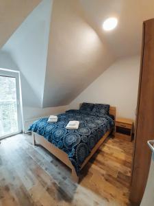 Schlafzimmer mit einem Bett mit blauer Decke in der Unterkunft Stevan Sremac in Sokobanja