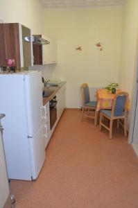 a kitchen with a table and a white refrigerator at Ferienwohnung Wunderlich in Krausnick