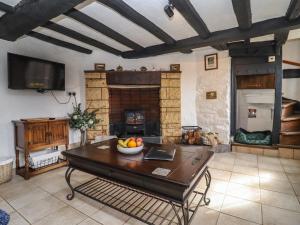 a living room with a table and a fireplace at Runnymede in Tewkesbury