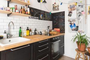 uma cozinha com armários pretos e um lavatório em Bright apartment in Aubervilliers em Aubervilliers
