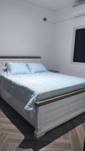 a bed in a white room with a television at Residencial la Toscana in Penonomé