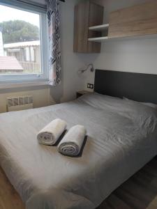 a bedroom with a bed with two towels on it at Mobil home 3 chambres Accès direct plage 4 Etoiles in Canet-en-Roussillon +1 photo