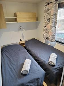 a bedroom with two beds with towels on them at Mobil home 3 chambres Accès direct plage 4 Etoiles in Canet-en-Roussillon