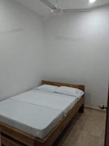 a bed in a room with a white wall at Apartamento Confort in Arboletes