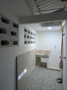 um quarto vazio com uma parede branca e um lavatório em Apartamento Confort em Arboletes