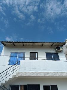 um edifício branco com janelas e um céu azul em Apartamento Confort em Arboletes