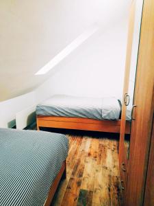 um quarto com 2 camas e piso em madeira em Stevan Sremac em Sokobanja