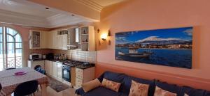 a kitchen and living room with a couch and a painting on the wall at MARENAXOS APaRTMENT in Giardini Naxos