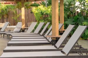 una fila di sedie bianche sedute sotto un padiglione di La Pagerie - Tropical Garden Hotel a Les Trois-Îlets