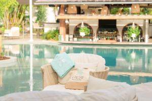 una sedia seduta di fronte alla piscina di La Pagerie - Tropical Garden Hotel a Les Trois-Îlets