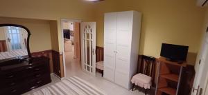 a bedroom with a mirror and a dresser and a television at MARENAXOS APaRTMENT in Giardini Naxos