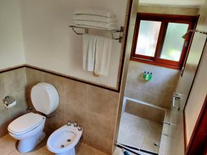 a bathroom with a toilet and a shower at Raices Amambai Lodges in Puerto Iguazú