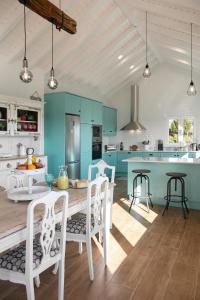 a kitchen with blue cabinets and a table and chairs at Casal Velho in Salir de Matos