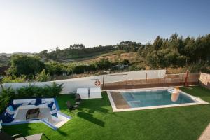 a backyard with a swimming pool and a lawn at Casal Velho in Salir de Matos