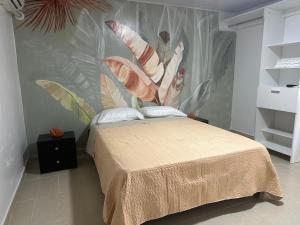 a bedroom with a bed with a mural on the wall at Leonor’s Guest House in Providencia
