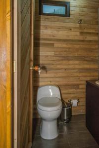 a bathroom with a toilet in a wooden wall at Eco Hotel The View in El Peñol