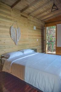 sypialnia z dużym łóżkiem w drewnianej ścianie w obiekcie Eco Hotel The View w mieście El Peñol