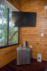 a kitchen with a microwave and a tv on a wall at Eco Hotel The View in El Peñol