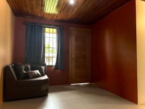 a living room with a couch and a window at Tico casita - Lero Stays in Fortuna