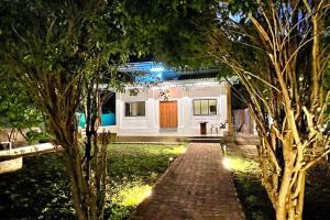 a house with a brick walkway in a yard at night at Forestville Villa in Thane
