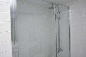a shower with a glass door in a bathroom at To see the sea apartment in Sesimbra
