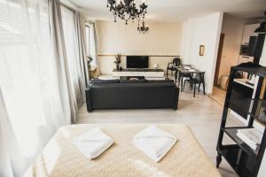 a living room with a bed and a dining room at ZARA LUXURY APARTMENTS The absolute center of Žilina in Žilina