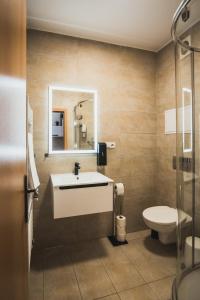 a bathroom with a sink and a toilet at ZARA LUXURY APARTMENTS The absolute center of Žilina in Žilina