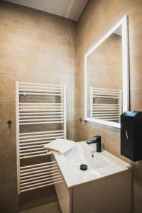 a bathroom with a sink and a mirror at ZARA LUXURY APARTMENTS The absolute center of Žilina in Žilina