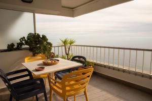 a table and chairs on a balcony with the ocean at To see the sea apartment in Sesimbra