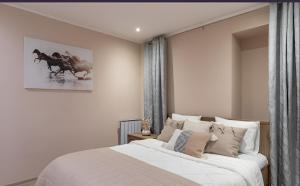Cozy apartment near the sea في تالين: غرفة نوم بسرير كبير مع شراشف بيضاء