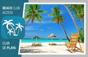 un club de playa con una silla de playa y palmeras en TROPICAL Studios Deluxe, en Punta Cana