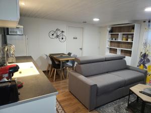 ein Wohnzimmer mit einem Sofa und einem Tisch in der Unterkunft Appartement 2 pièces près du lac de Bouzey in Sanchey