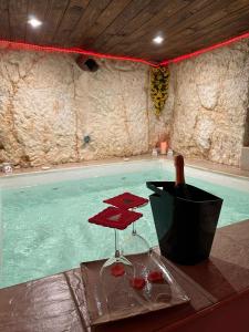 uma piscina com uma garrafa de vinho e copos de vinho em Tama67 suite em Ostuni