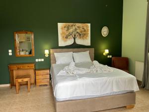 a bedroom with a large bed with a green wall at Akrotiri studios in Samothráki