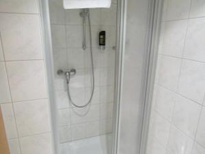 a shower with a hose in a bathroom at Pension Hexenkessel in Wernigerode