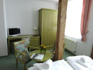 a room with a table and a desk with a computer at Pension Hexenkessel in Wernigerode