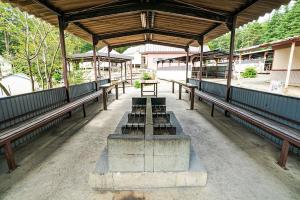 un pabellón con bancos y una mesa en él en Shinei Kiyosato Campsite - Vacation STAY 42245v, en Hokuto