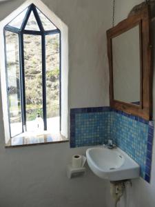 a bathroom with a sink and a mirror and a window at Casa Luis in Hermigua