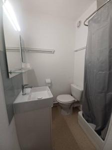 een witte badkamer met een wastafel en een toilet bij Studio classé 2 étoiles, à 200m de la plage de Nauzan parking gratuit in Vaux-sur-Mer