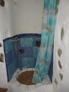 a bathroom with a shower with a blue shower curtain at Casa Luis in Hermigua