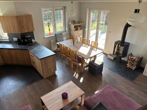 a kitchen and dining room with a table and a stove at DOM NA KASZUBACH, SAUNA i BALIA in Nowe Czaple