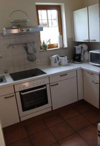a kitchen with white cabinets and a stove top oven at Haus an der Drau in Feistritz im Rosental