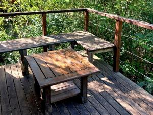 a wooden table and bench sitting on a wooden deck at Cabaña enero soleado in Tigre