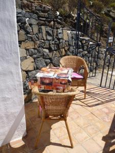 a table and chairs on a patio with a stone wall at Casa Luis in Hermigua