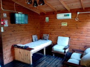 a room with a bed and a chair in a cabin at Cabaña enero soleado in Tigre