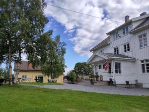 Una casa blanca con una bandera. en Granum Gård, en Fluberg